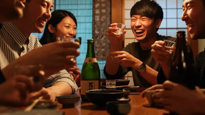 A person pouring sake from a tokkuri into an o-choko